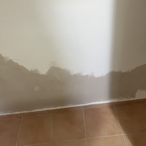 קיר עם תיקוני טיח ורצפת אריחים