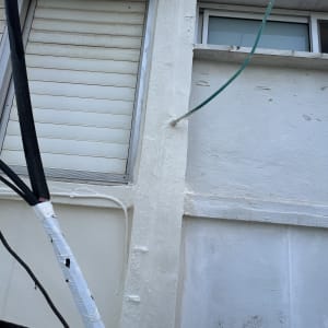 צינור ירוק מחובר לגג עם כבלים שחורים