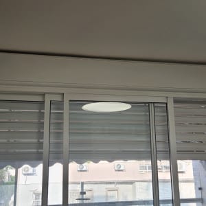 חלון הזזה מאלומיניום עם תריס גלילה וארגז תריס מותקנים בבית