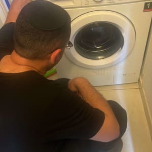 אדם בודק מכונת כביסה טלפונקן