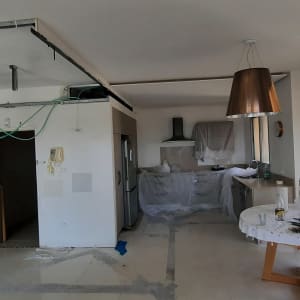 מטבח בשיפוץ עם כבלים חשופים ויריעות פלסטיק