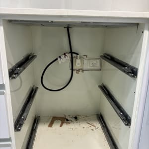 שקע חשמל וכבל שחור בתוך ארון פתוח