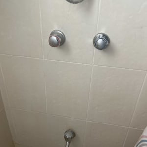 ברזים ומקלחת על קיר אריחים