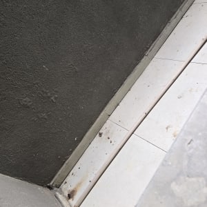 רצפה עם כתמי רטיבות ליד קיר אפור