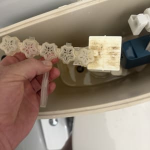 תמונה של פנים מיכל אסלה עם יד מחזיקה חלק פלסטיק