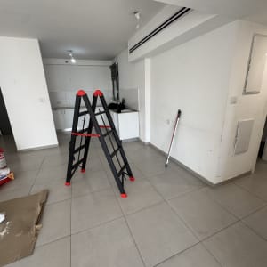 סולם וכלי עבודה בחדר עם קירות צבועים