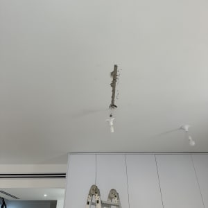 סולם מתכת מתחת לתקרה עם חוטי חשמל חשופים