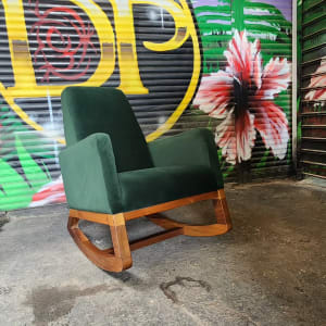 כורסה ירוקה עם בסיס עץ על רקע גרפיטי צבעוני