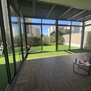 חדר עם חלונות אלומיניום וגינה בחוץ