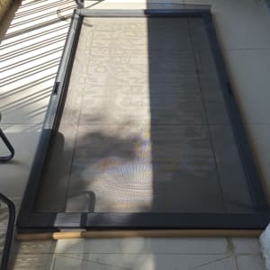 רשת חלון על רצפת מרפסת עם צמח בעציץ