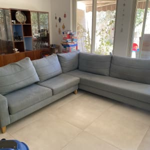 ספה אפורה גדולה עם כריות על רצפת אריחים