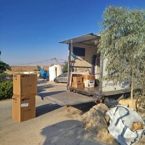 משאית פתוחה עם קופסאות קרטון על הקרקע