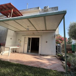 פרגולה אלומיניום בחצר עם שולחן וכיסאות