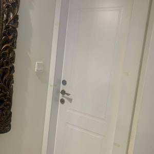 דלת לבנה עם ידית כסופה ומנעול