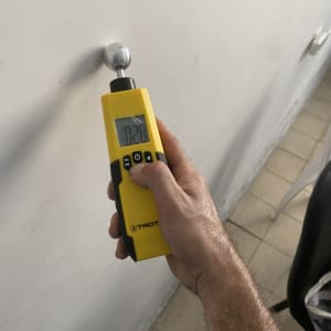 מכשיר מדידה צהוב על קיר לבן