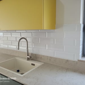 כיור מטבח עם ברז, אריחים לבנים על הקיר