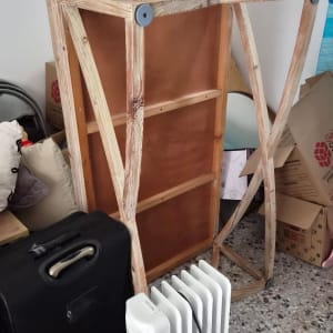 שולחן עץ, ארגזי קרטון ומזוודה עמוסים בחדר לקראת הובלת דירה