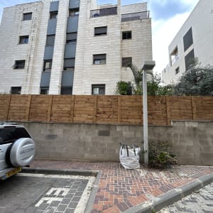 גדר עץ חדשה ליד בניין מגורים