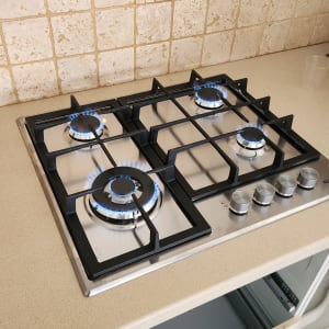 כיריים גז עם להבות כחולות על משטח מטבח