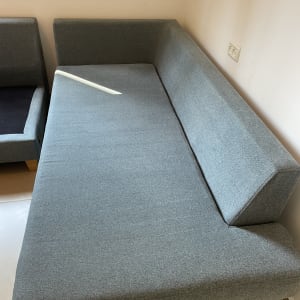 ספה אפורה בחדר עם קיר לבן