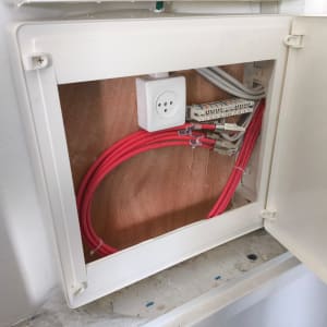 ארון תקשורת עם כבלים אדומים ולוח חיבורים