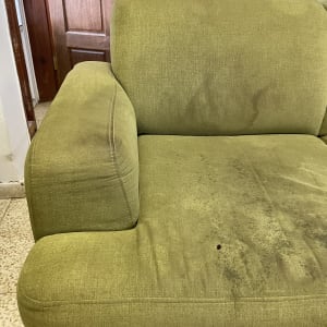 ספה ירוקה עם כתמים ולכלוך על המושב