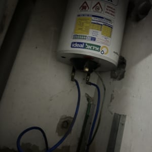 דוד שמש עם צינורות כחולים מחוברים לקיר