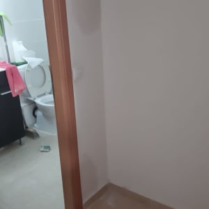 אקדח סיליקון על לוח לבן ליד קיר צבוע