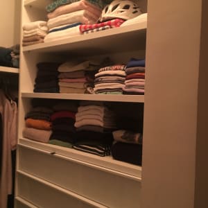 מדפים עם מגבות מקופלות וקסדה לבנה