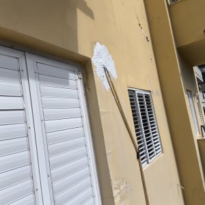 קיר צבוע עם תיקון טיח ומברשת צביעה