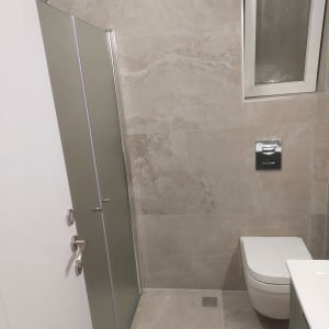 חדר אמבטיה עם מקלחון ודלת זכוכית