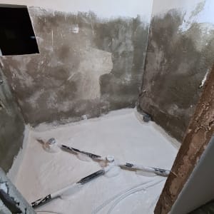 רצפה עם צינורות חשופים וטיח על הקירות