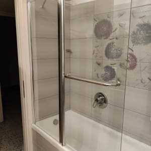 מקלחת עם דלת זכוכית וברז מתכת