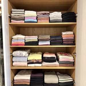 בגדים מקופלים ומסודרים בארון עץ פתוח