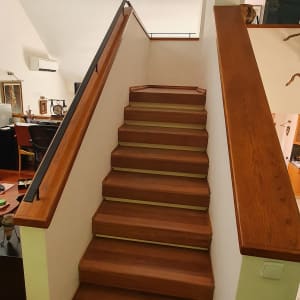 מעקה עץ ומסגרת מתכת במדרגות פנימיות