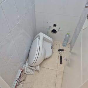 אסלה מנותקת, פטיש, פלס ומגבות על הרצפה