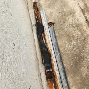 צינורות חלודים מונחים על רצפה בטון