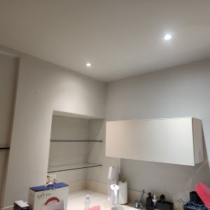 קיר צבוע בלבן עם מדפים מזכוכית