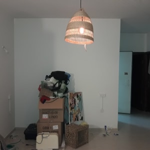 מנורה תלויה עם נורה דולקת על תקרה לבנה