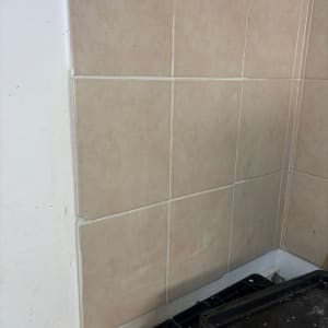 אריחי קרמיקה מותקנים על קיר ליד כיריים