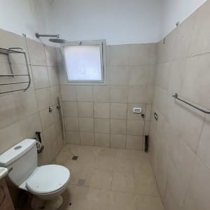 חדר אמבטיה עם שירותים, מקלחת וקירות מרוצפים