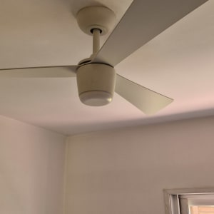 מאוורר תקרה לבן מותקן בחדר עם חלון