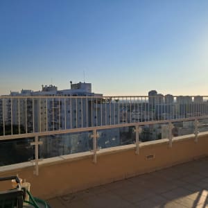 מעקה מתכת לבן על מרפסת עם נוף עירוני