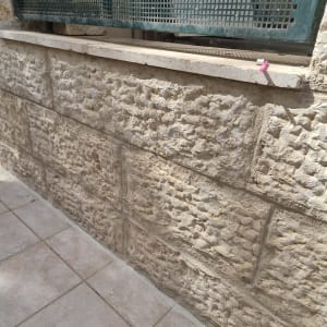 קיר אבן עם ריצוף קרמיקה בחוץ