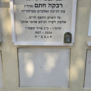 מצבה עם כיתוב בעברית על קיר חיצוני