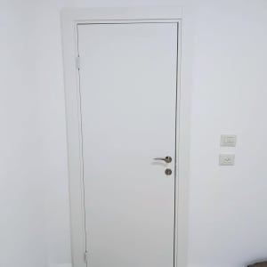 דלת לבנה עם ידית כסופה וקיר לבן