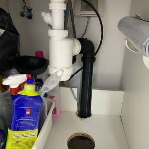 צנרת פלסטיק לבנה ושחורה מתחת לכיור