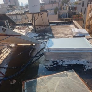 גג עם חומרי איטום, דלי וצינורות