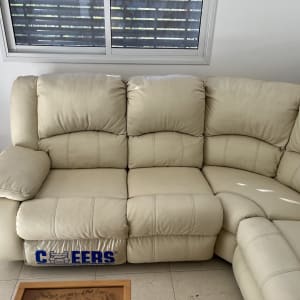 ספה בהירה ליד חלון עם תריסים סגורים