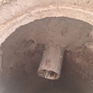 צינור ביוב עם מים זורמים לתוך בור